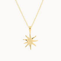 Gold sun-shaped pendant on a chain against a white background