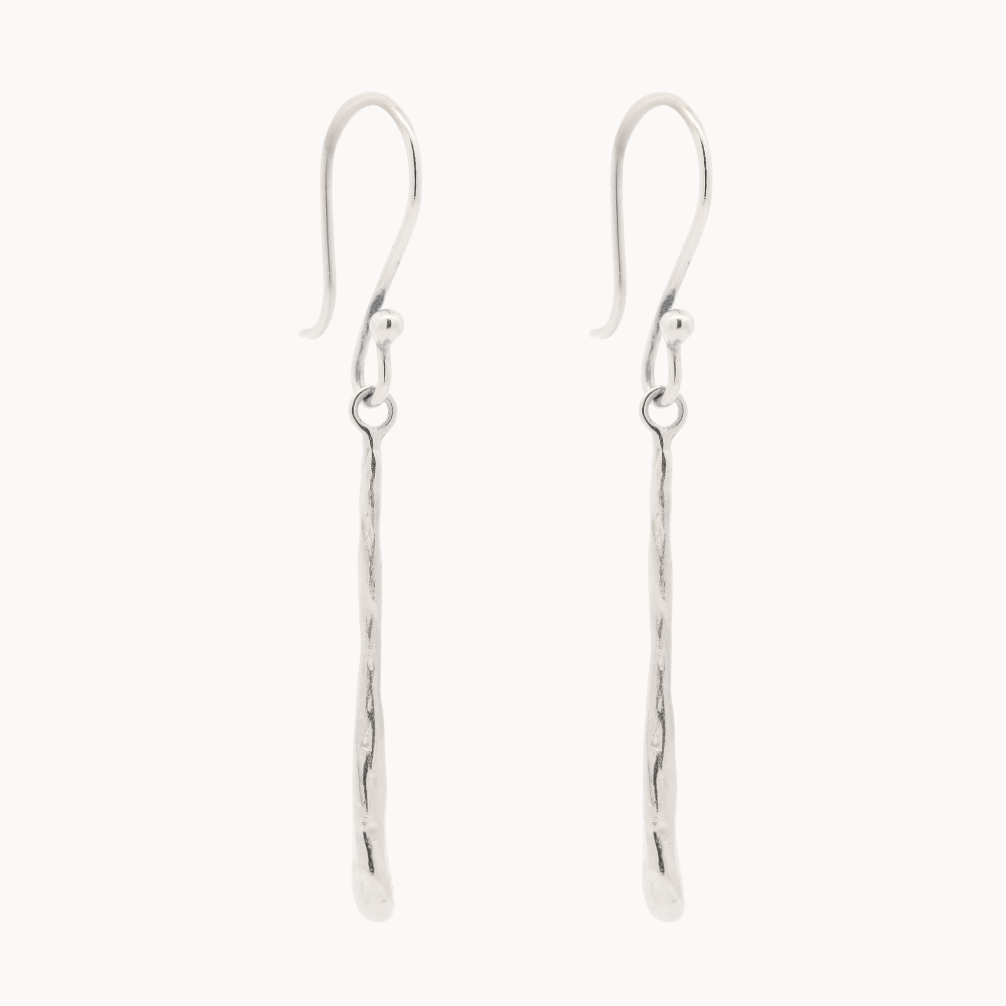 Pair of white gold hook dangle earrings with molten drop detail on a white background