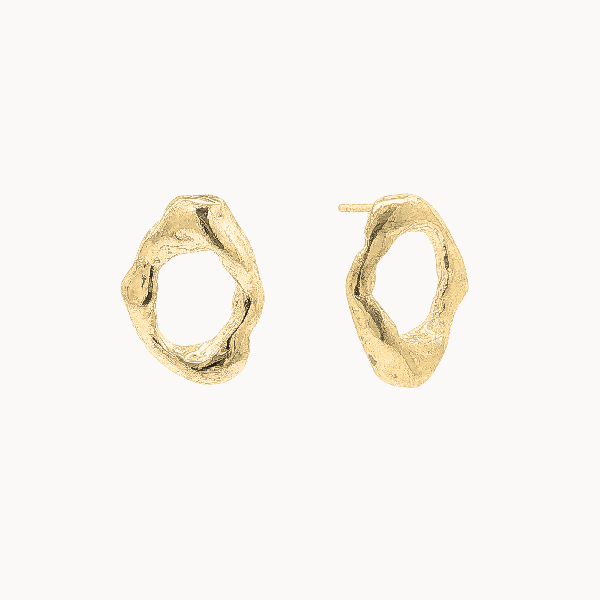 A pair of organic-shaped open oval stud earrings with a textured, hammered finish, displayed on a clean off-white background.