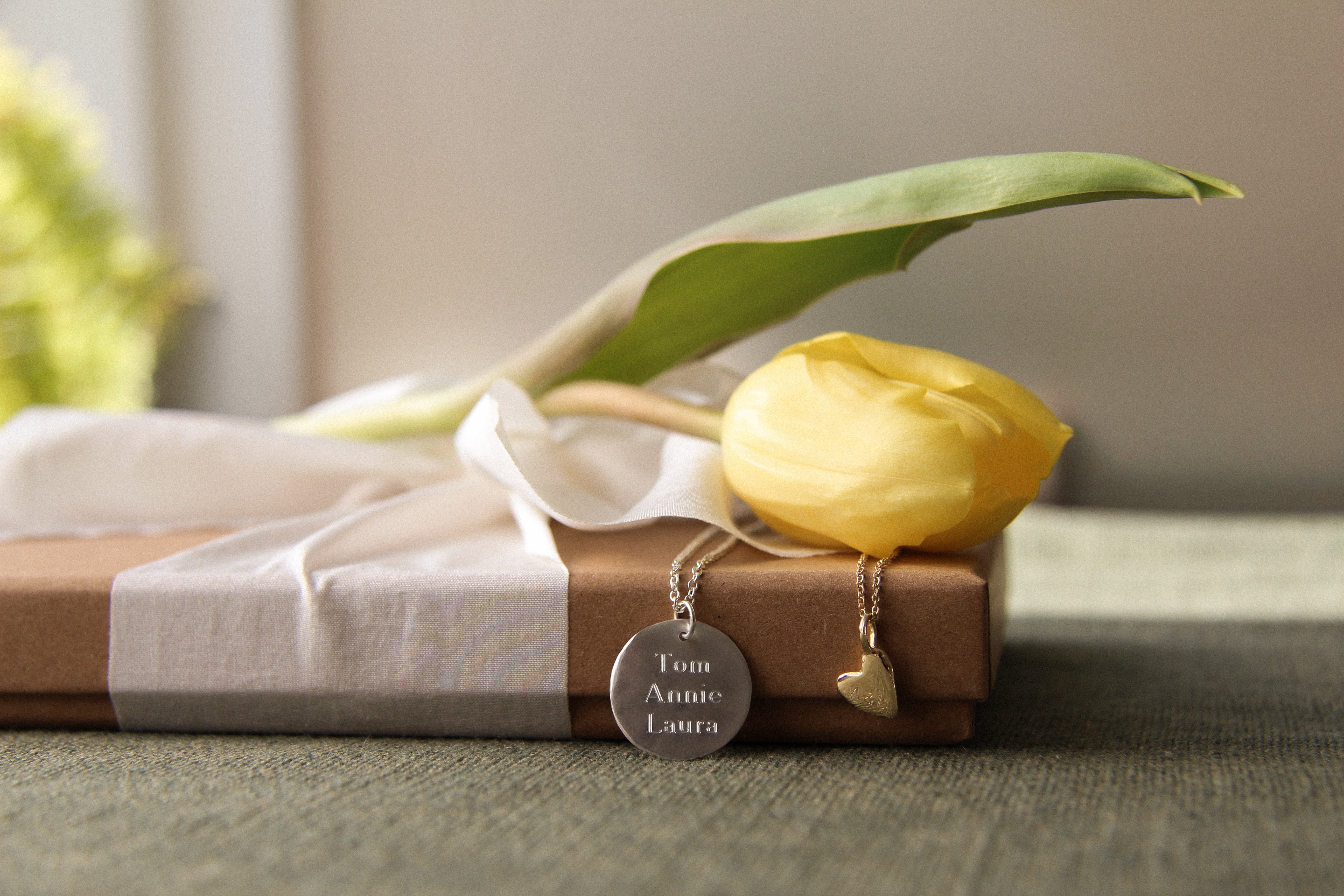 engraved necklaces with names on a gift box with yellow tulip for mothers day jewellery gift ideas