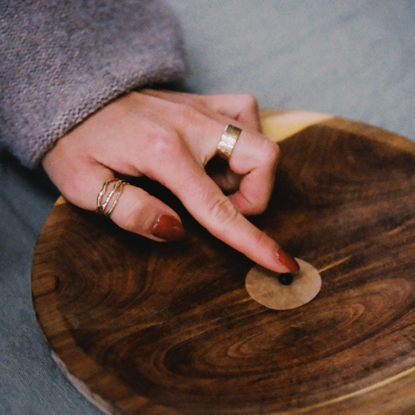 Hand with rings on a wooden surface