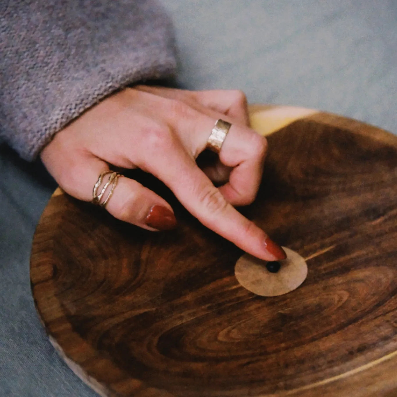 Hand with rings on a wooden surface