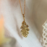 oak leaf necklace in gold with candle and lace fabric