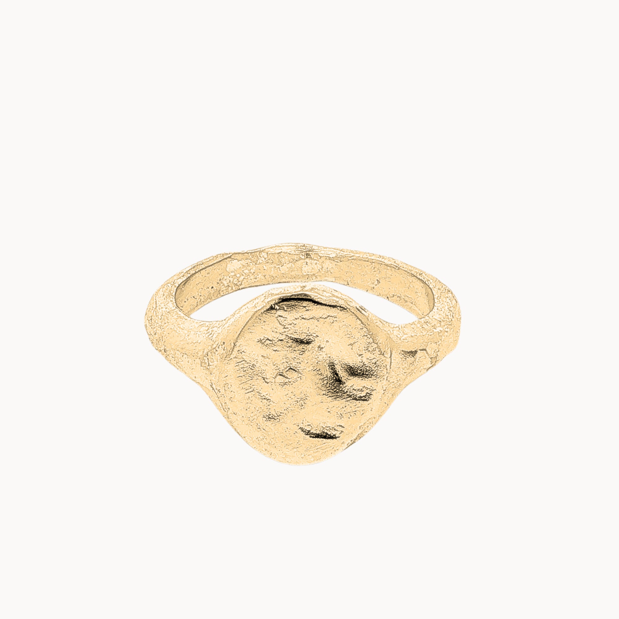 A textured gold signet ring with a rough, organic surface finish, shown on a plain off-white background.
