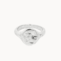A textured sterling silver oval signet ring with a rough, organic-shaped face, shown on a plain off-white background.