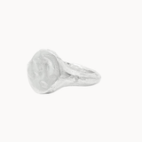 A textured sterling silver signet ring with a chunky, organic-shaped oval face, shown on a plain off-white background.