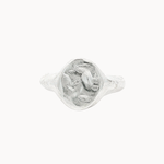 A textured sterling silver oval signet ring featuring a raised, organic-shaped face, shown on a plain off-white background.