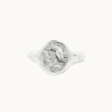 A textured sterling silver oval signet ring featuring a raised, organic-shaped face, shown on a plain off-white background.