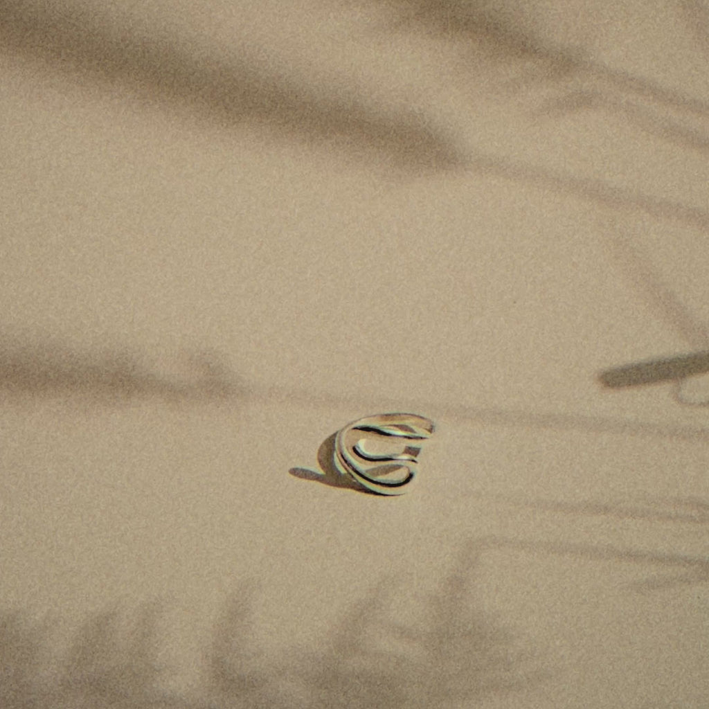 s-shaped silver ring with moving plant shadows