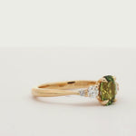 green sapphire ring with 4 diamonds spinning on a turntable