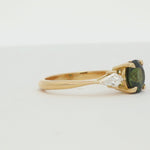 green sapphire engagement ring with round centre stone and kite shaped diamonds spinning on a turntable
