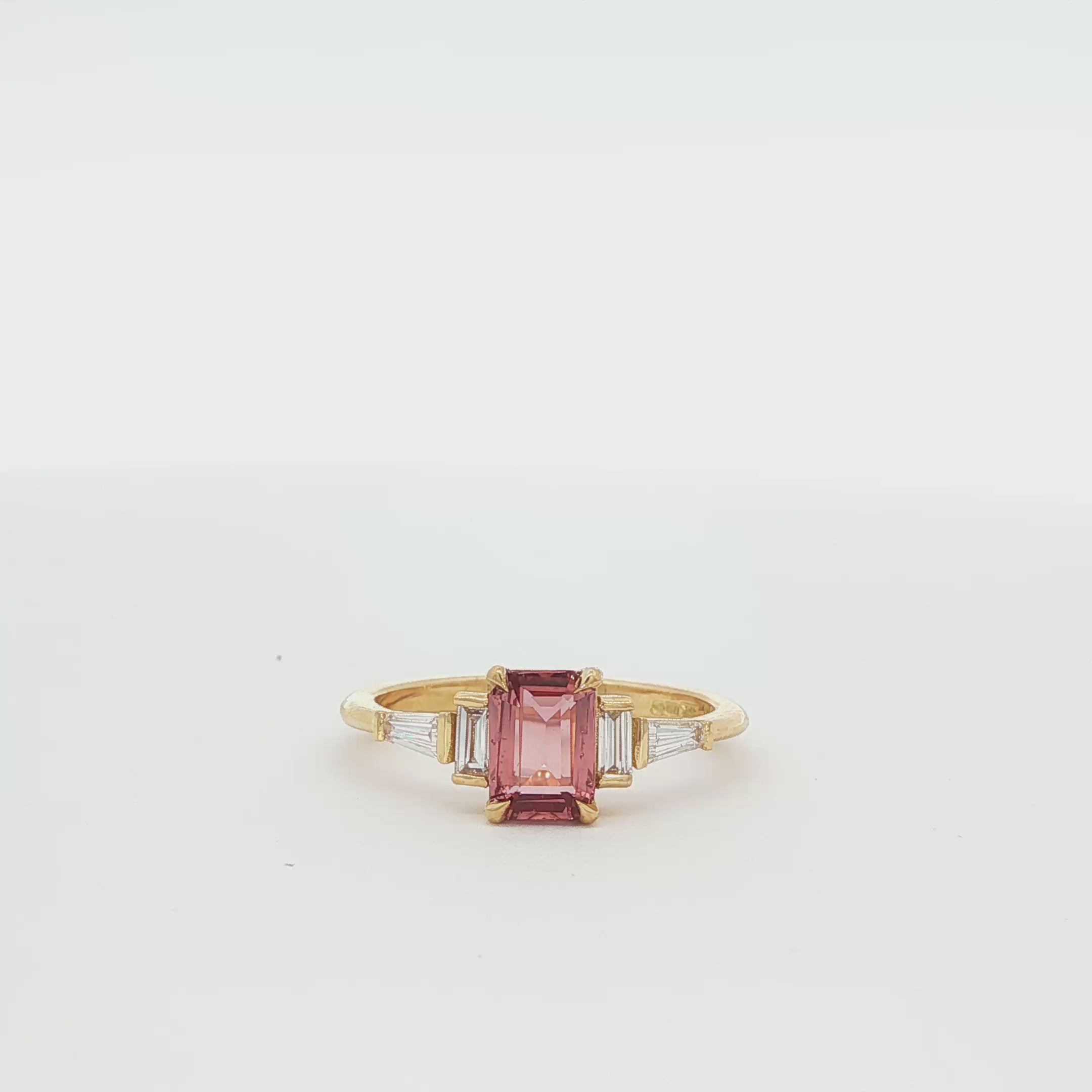 360 video of a peachy pink sapphire engagement ring with diamonds spinning