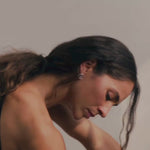 woman wearing silver spiral earrings doing yoga in slow motion