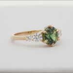 round green blue sapphire engagement ring with round diamonds spinning on a turntable