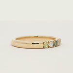 gold band ring with diamonds and green blue sapphires spinning on a turntable