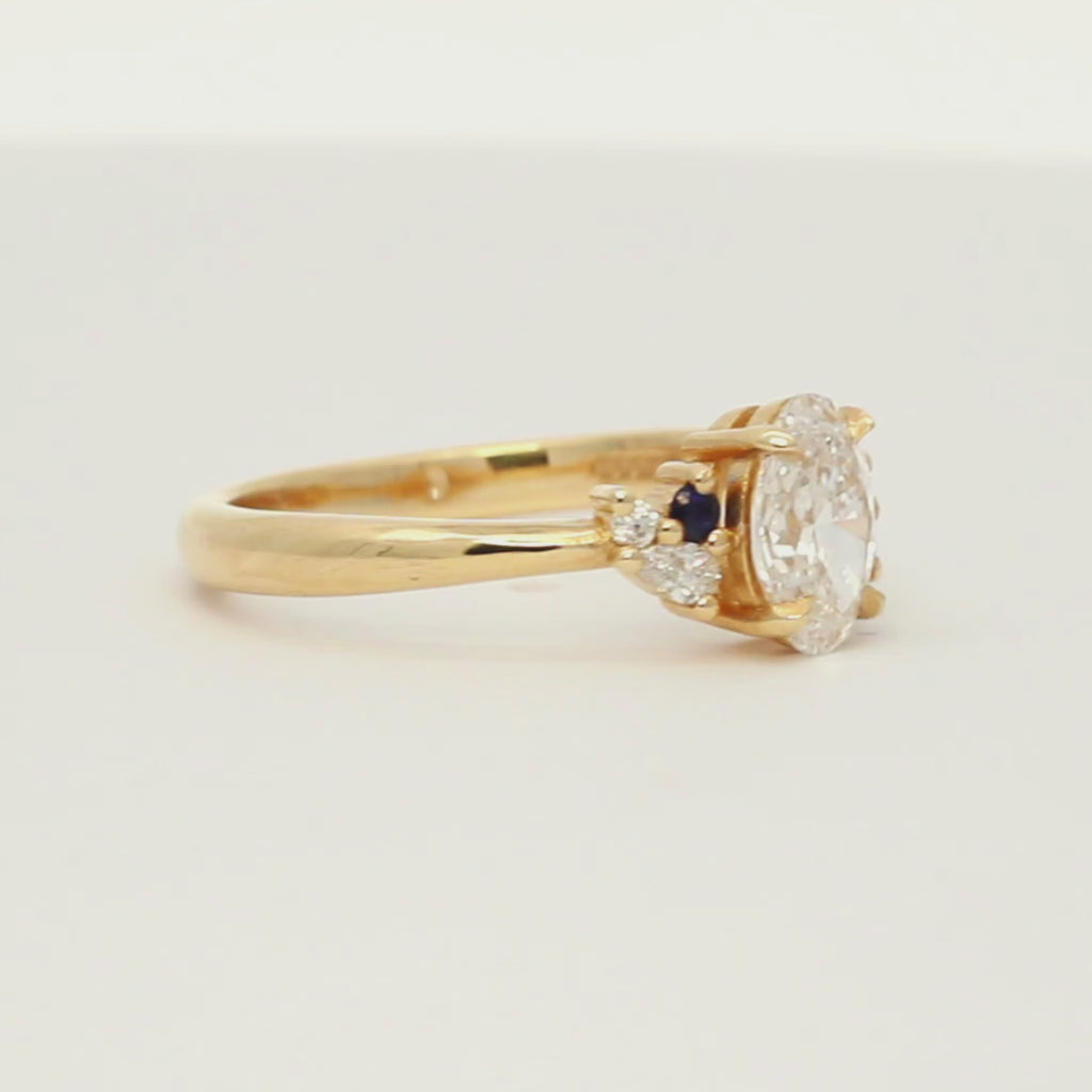 diamond engagement ring with small blue sapphires spinning on a turntable