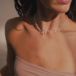 woman wearing strapless top and beaded silver necklace doing yoga in sunlit room