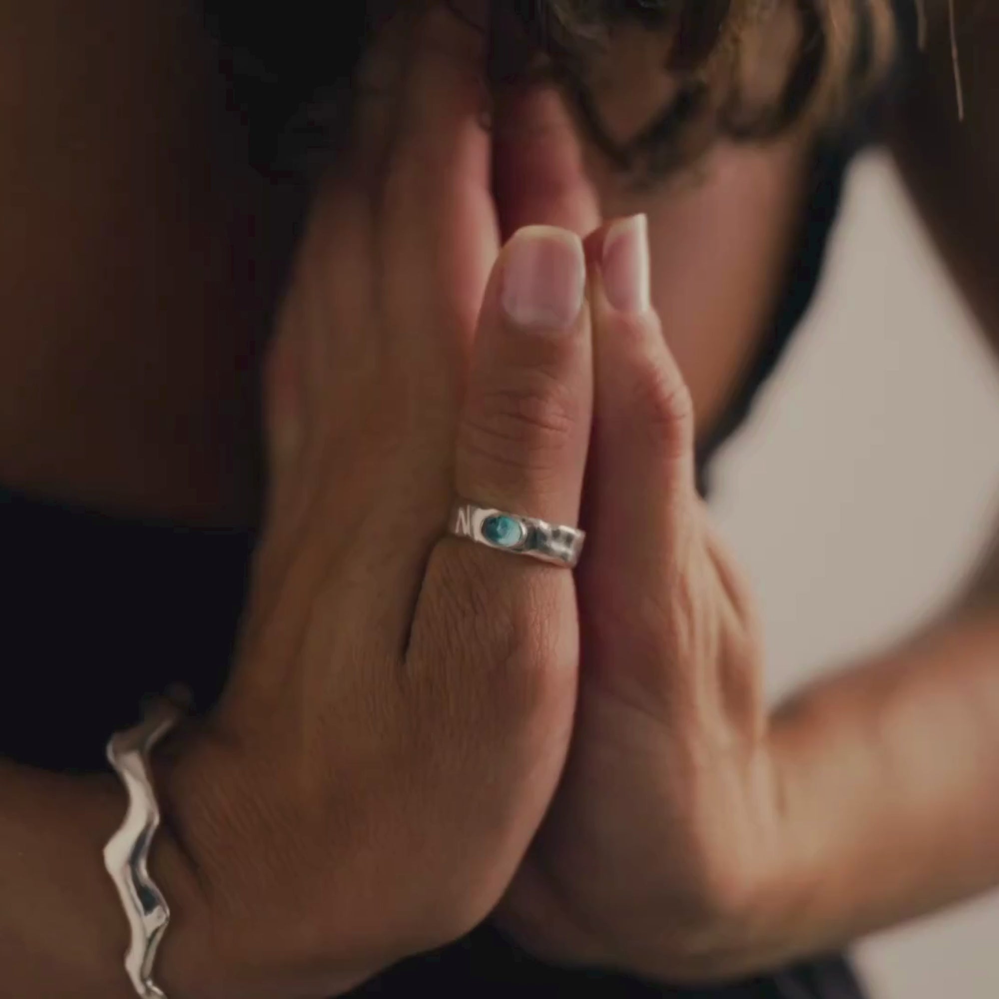 woman wearing silver ring with blue topaz with hands behind her back and doing yoga poses