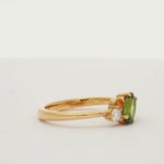 engagement ring with green, pink and yellow sapphires and diamonds spinning on a turntable