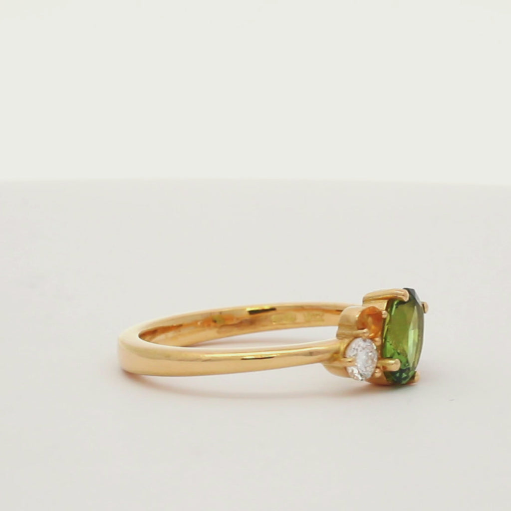 engagement ring with green, pink and yellow sapphires and diamonds spinning on a turntable