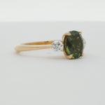 large rounded-oval sapphire engagement ring with round diamonds spinning on a turntable