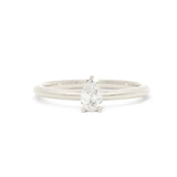 A pear-cut diamond engagement ring set on a slim white gold or platinum band, photographed against a seamless white background.