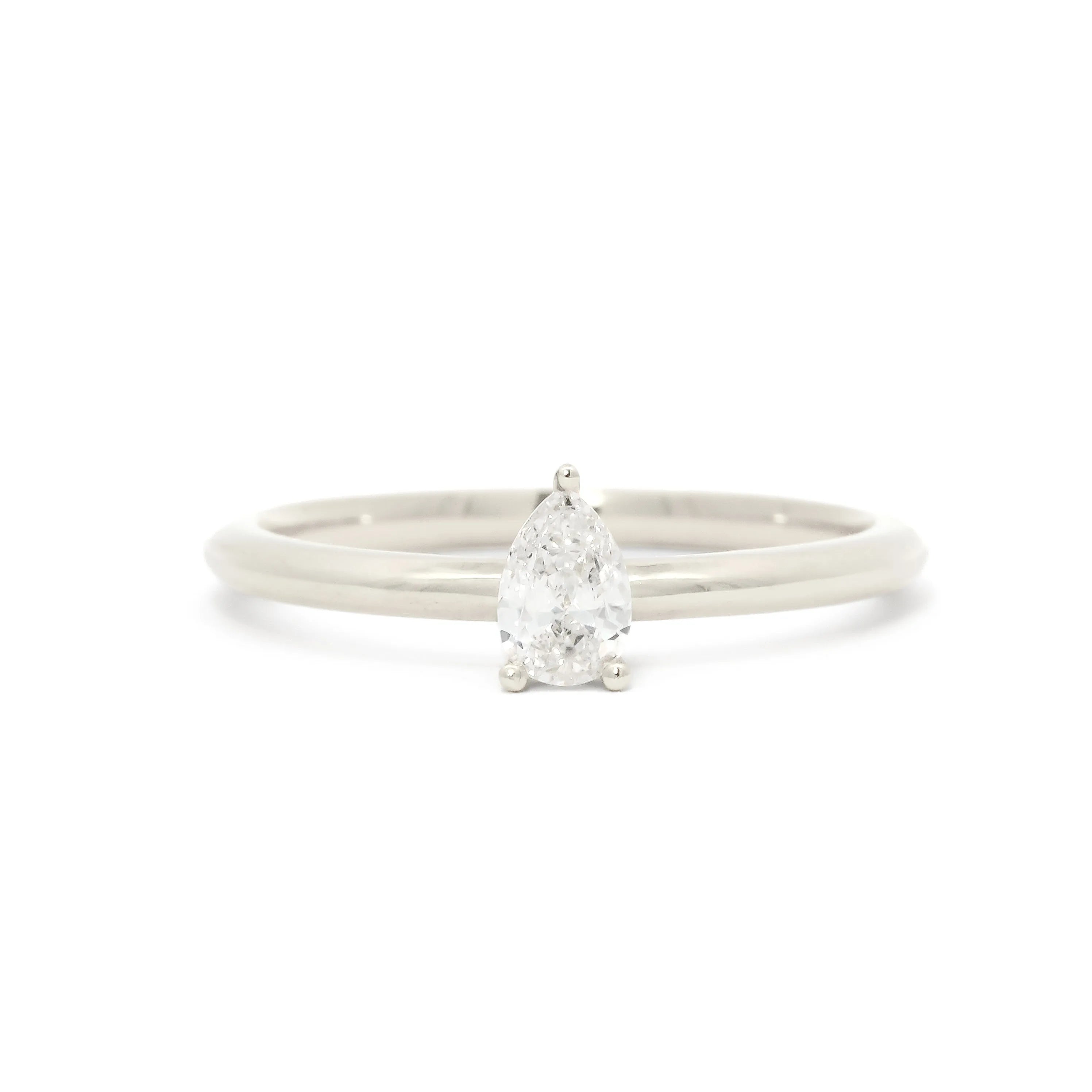 A pear-cut diamond engagement ring set on a slim white gold or platinum band, photographed against a seamless white background.