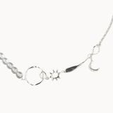 Silver necklace with various pendants and clear beads on a white background