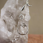 sun circle and bead necklace on white crystal and blurred background