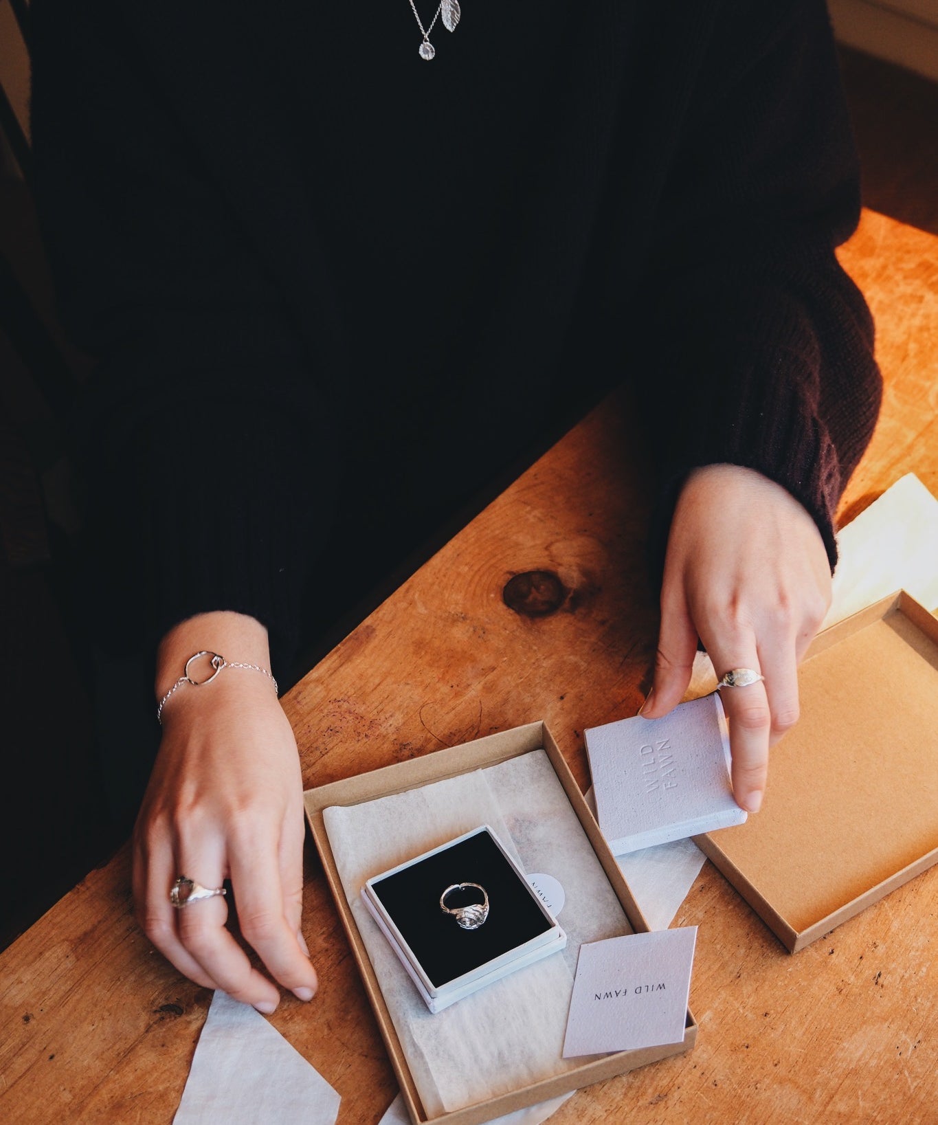 Person holding a box with a ring inside on a wooden table