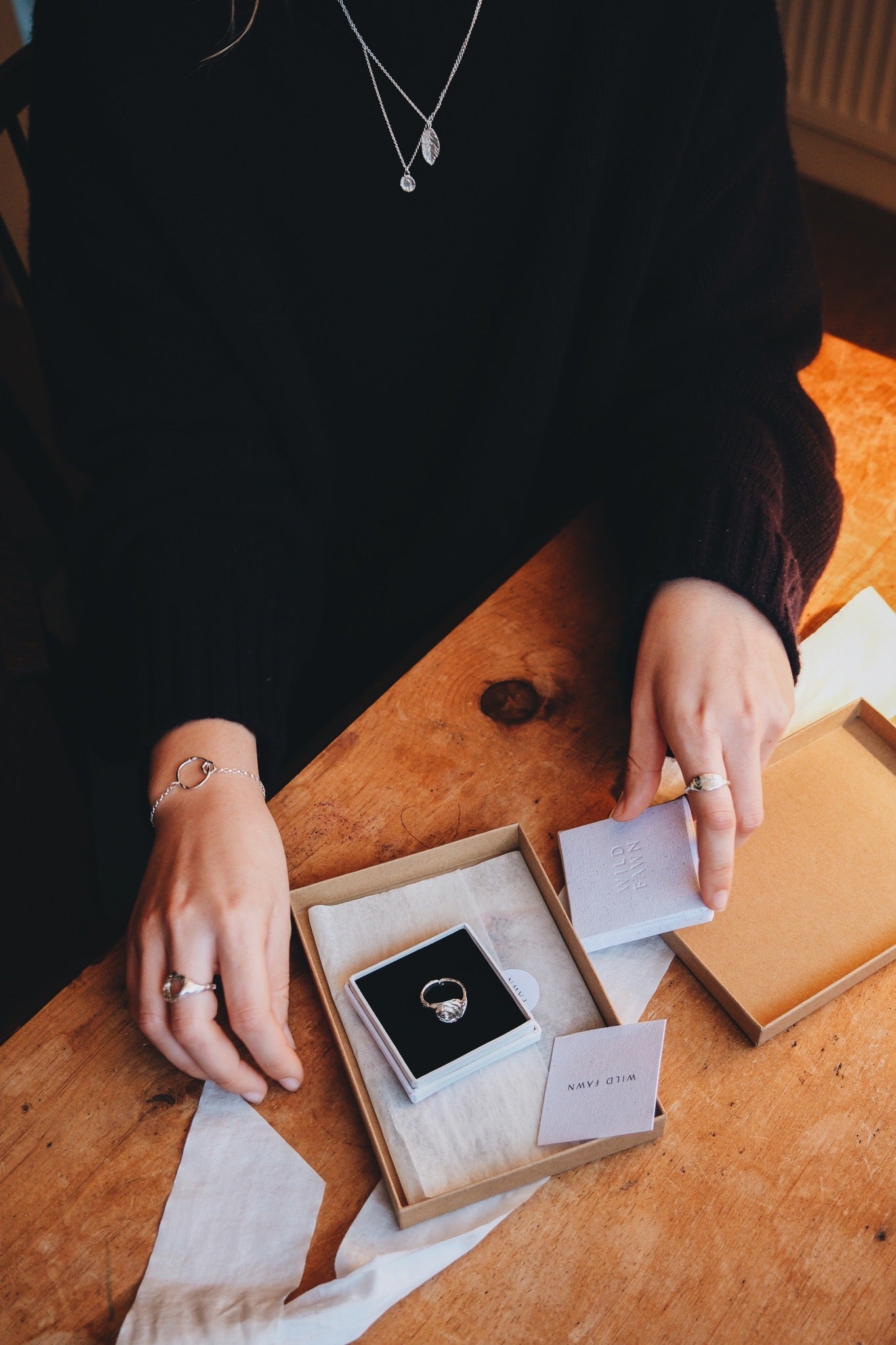 Person holding a box with a ring inside on a wooden table