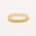 Gold wedding ring with soft satin texture finish on a white background