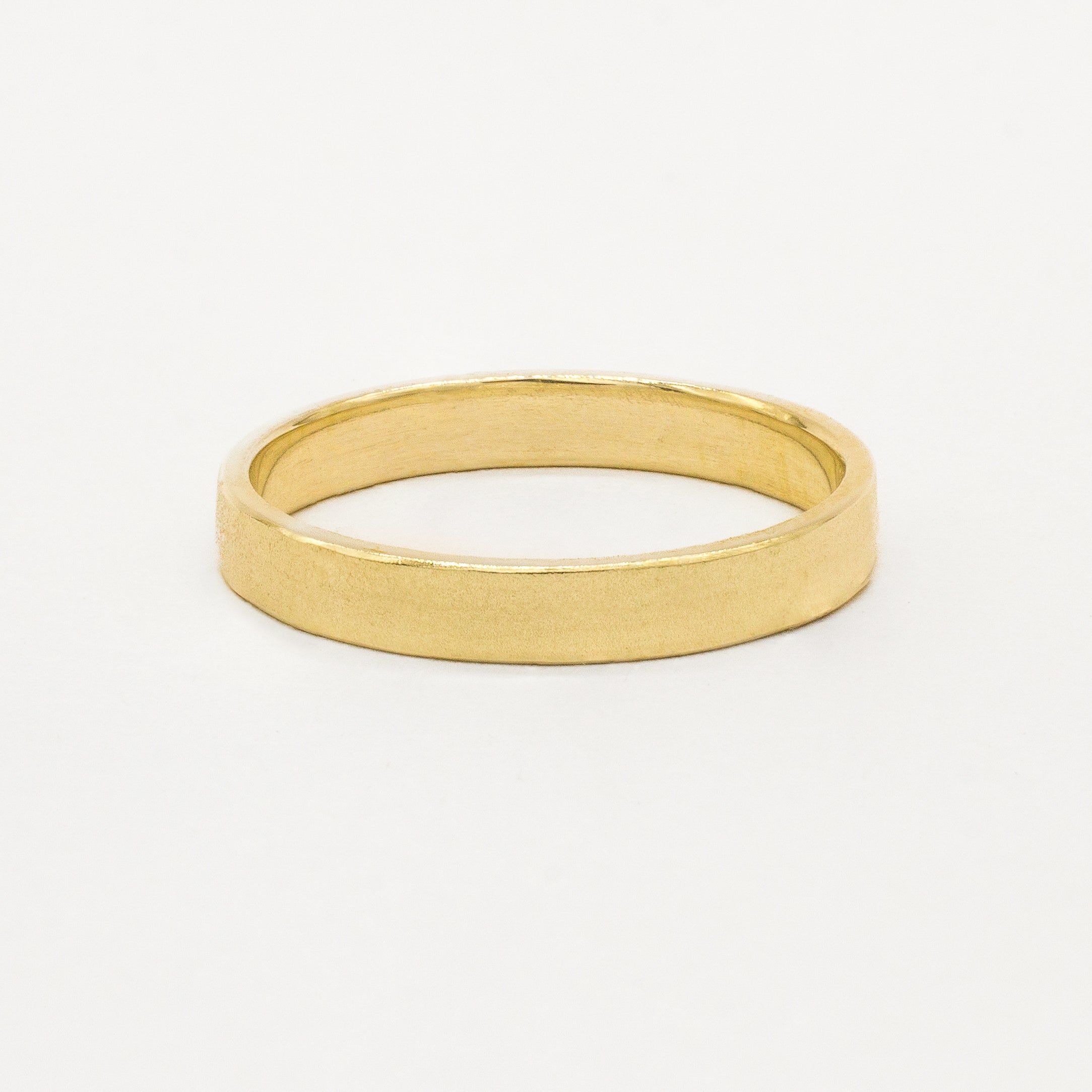 Gold satin flat wedding ring on a white background