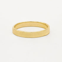 Gold satin flat wedding ring on a white background