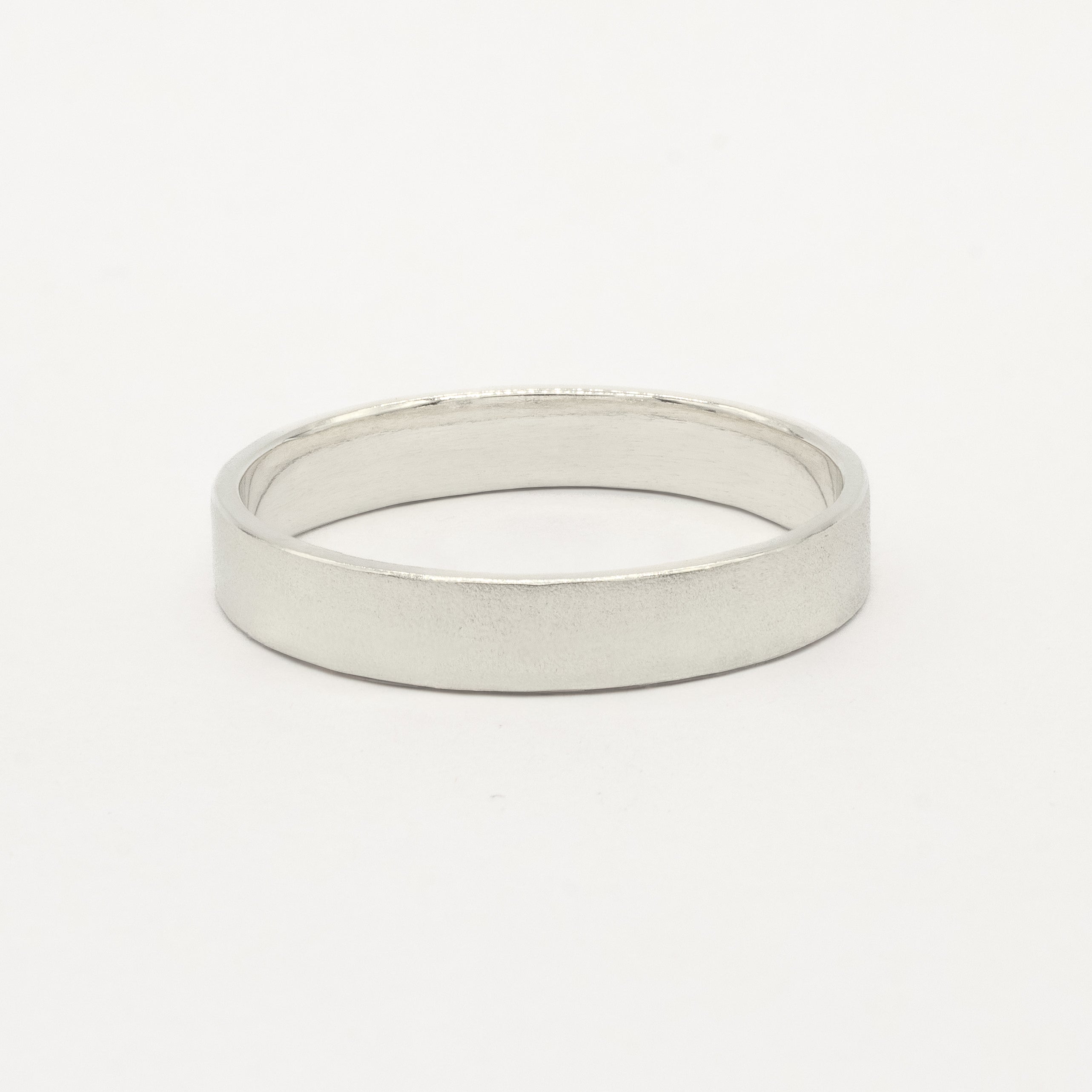 4mm wide white gold flat wedding ring with satin finish on white background