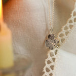 silver 4 leaf clover necklace with candle and lace fabric
