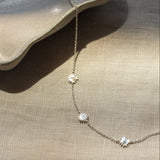 Necklace with star-shaped pendants on a beige fabric background