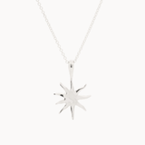 Silver-toned mini sun-shaped pendant on a chain against a white background
