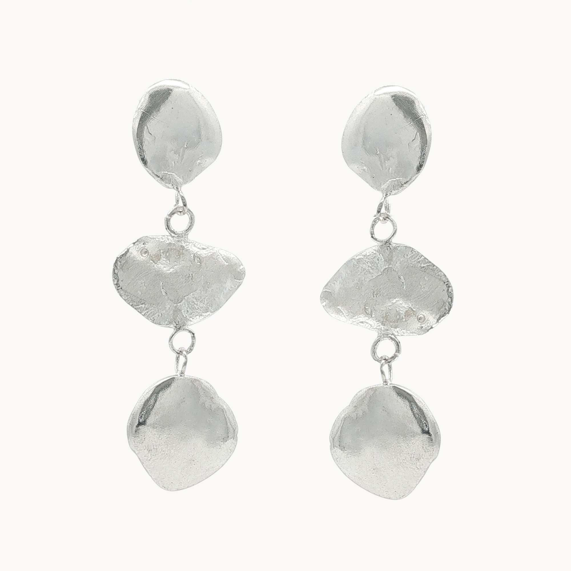 dangle earrings each with three pebble-like disks on a white background