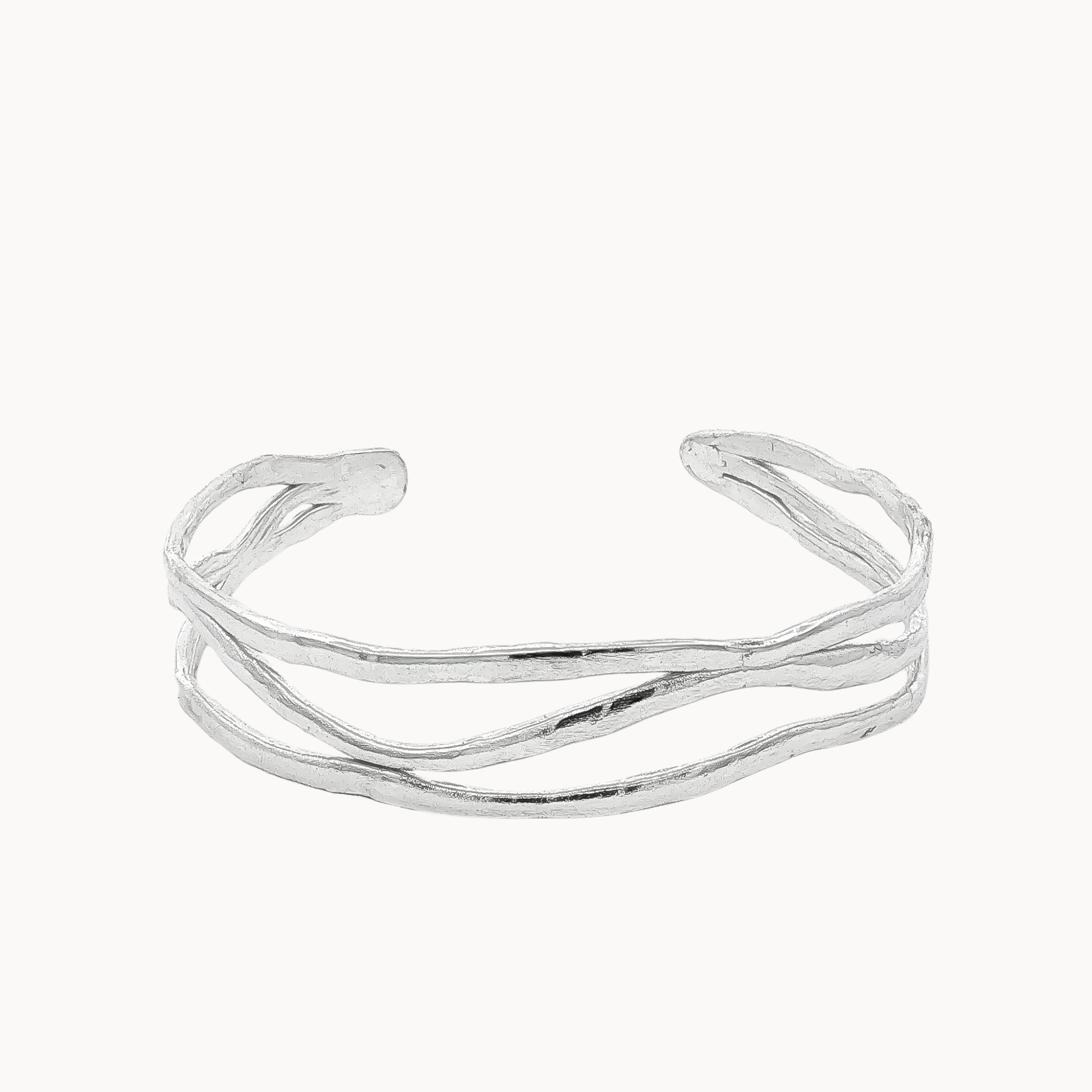 A silver open cuff bracelet with a wavy, organic textured design, photographed on a clean off-white background.