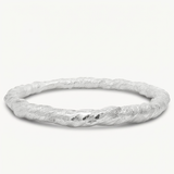 A textured silver bangle bracelet with a twisted, organic surface finish, displayed on a clean off-white background.