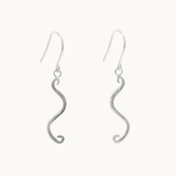 A pair of silver dangle earrings with a textured, wavy S-shaped drop and fishhook wires, shown against a plain off-white background.