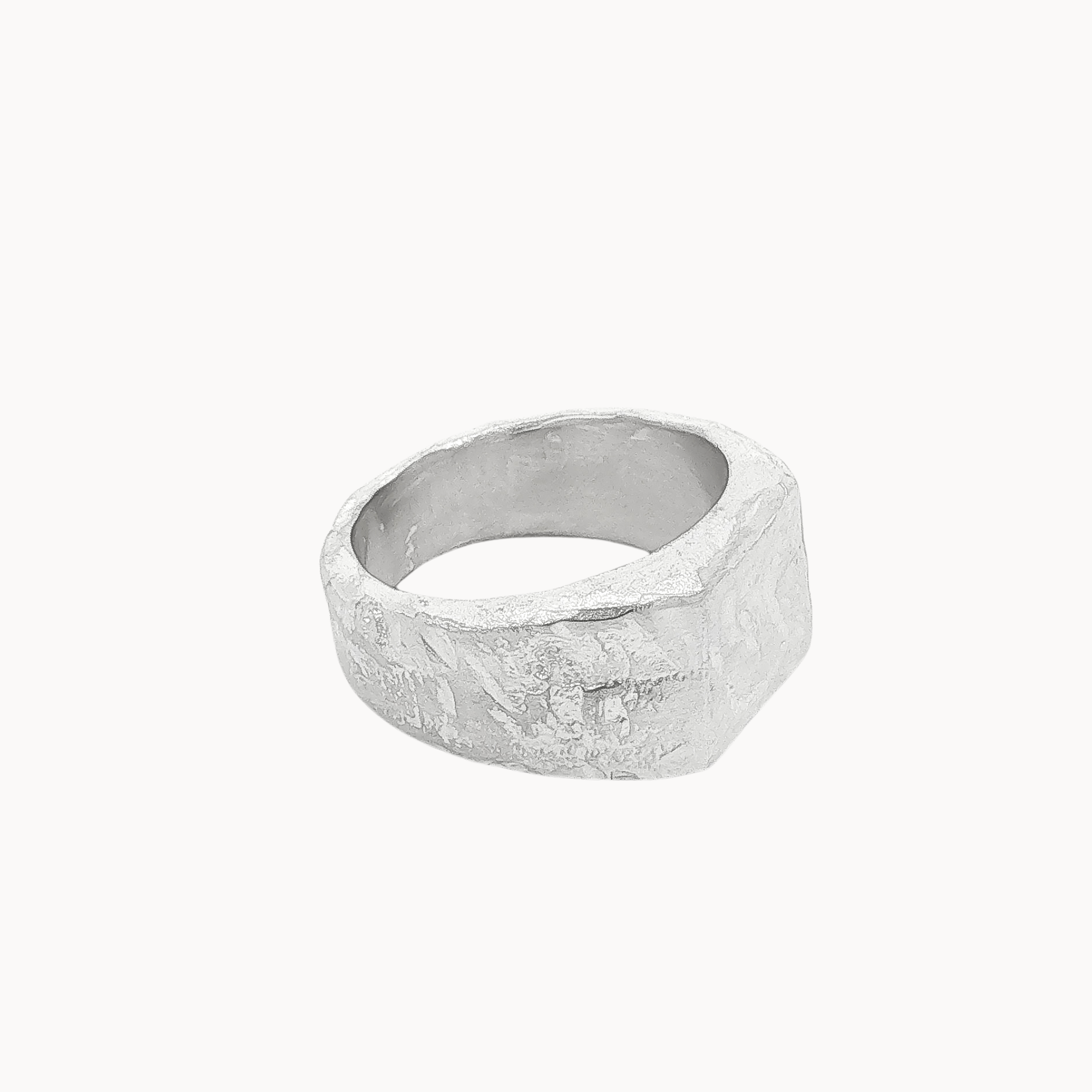 A textured silver square signet ring with a wide, chunky band and a hammered, organic surface finish, shown on a plain off-white background.
