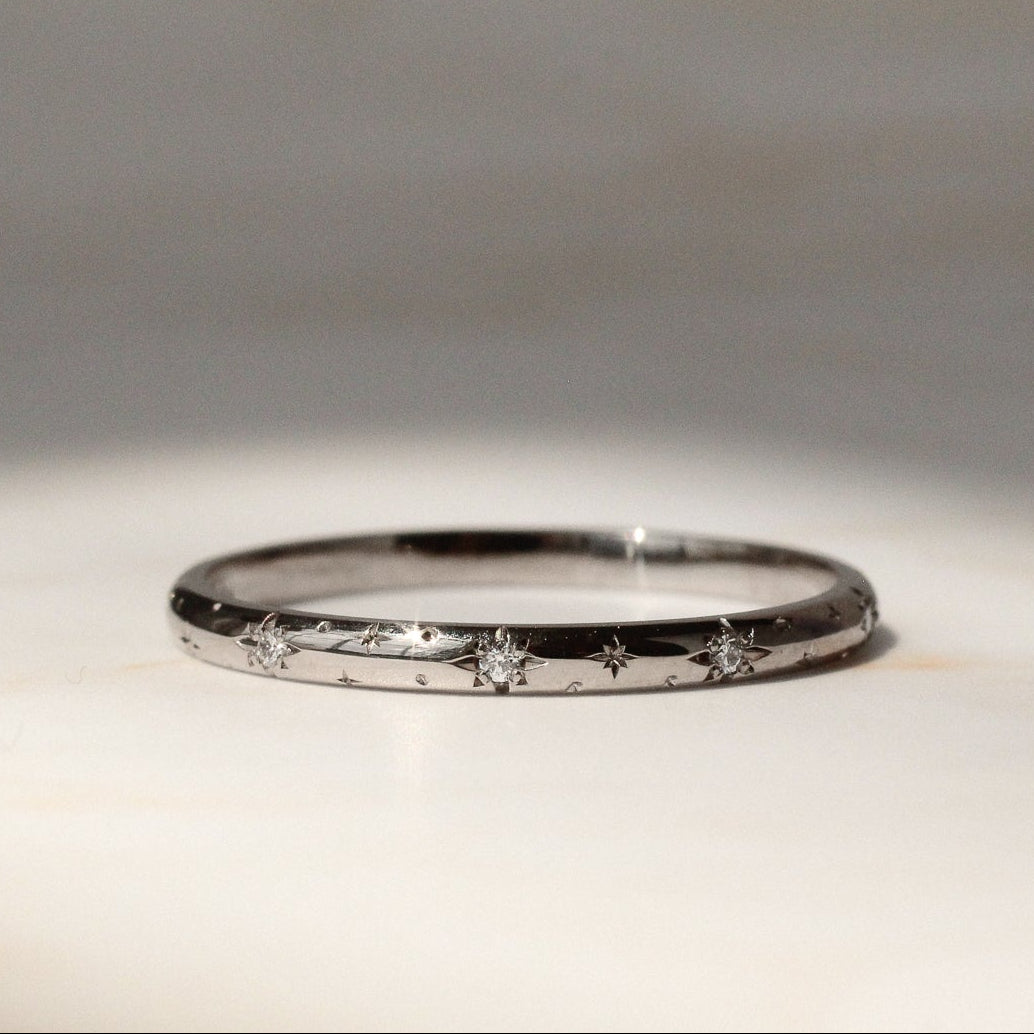 Star and diamond wedding ring in 18 carat white gold on a marble surface