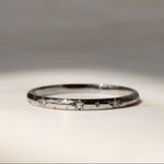 Star and diamond wedding ring in 18 carat white gold on a marble surface