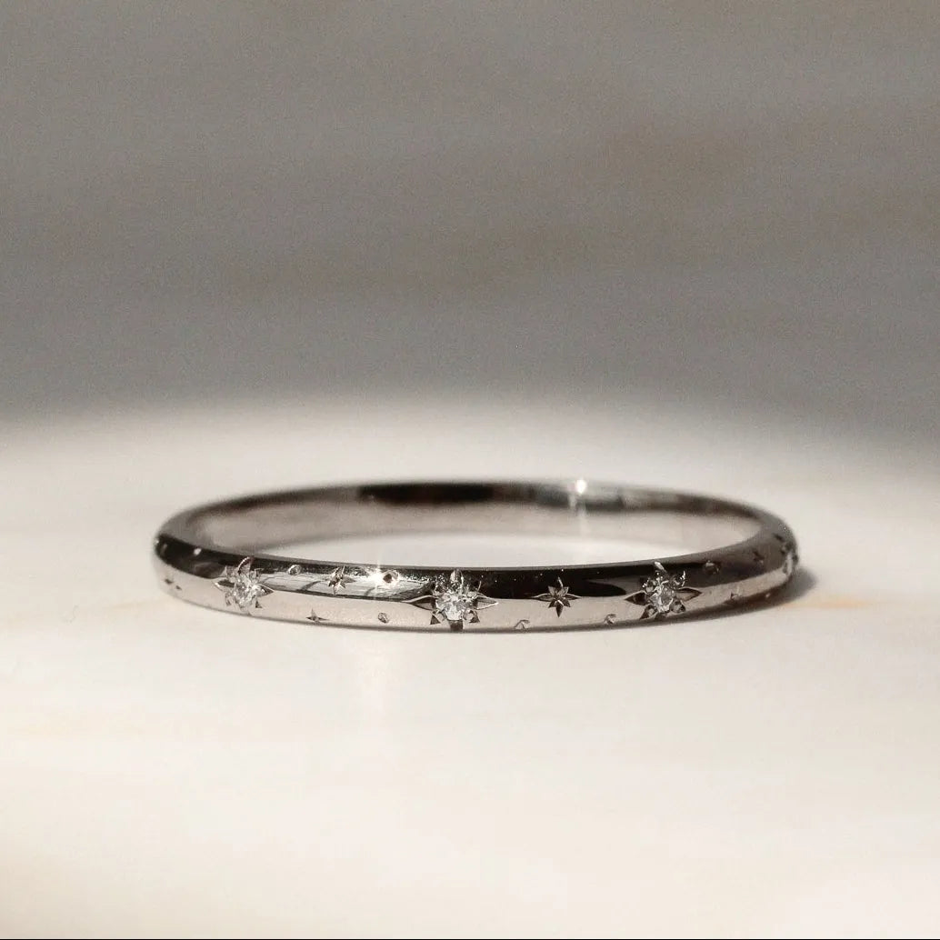 Star and diamond wedding ring in 18 carat white gold on a marble surface