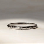 Star and diamond wedding ring in 18 carat white gold on a marble surface