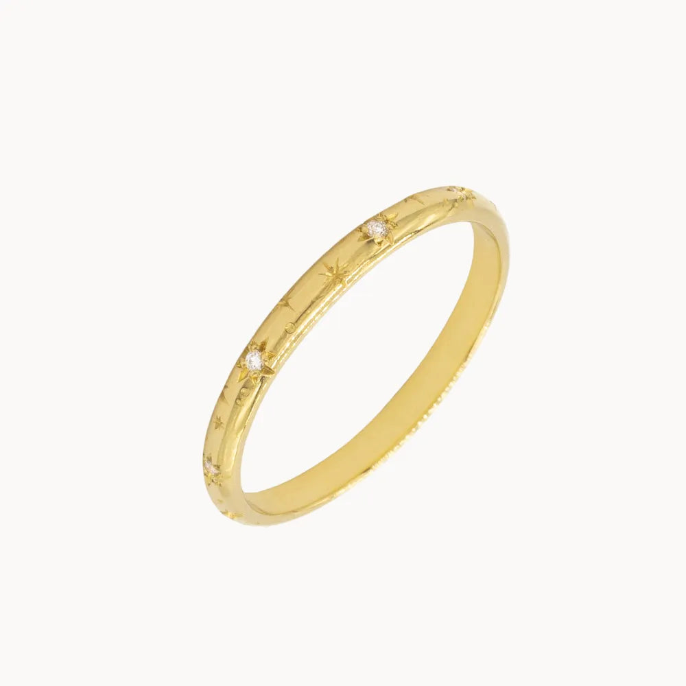 slanted cut out of yellow gold wedding ring with star engraving and small round diamonds and shadow