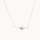 white gold four point star necklace on a fine chain against a white background