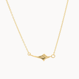 Gold necklace with a small four-pointed star pendant on a white background